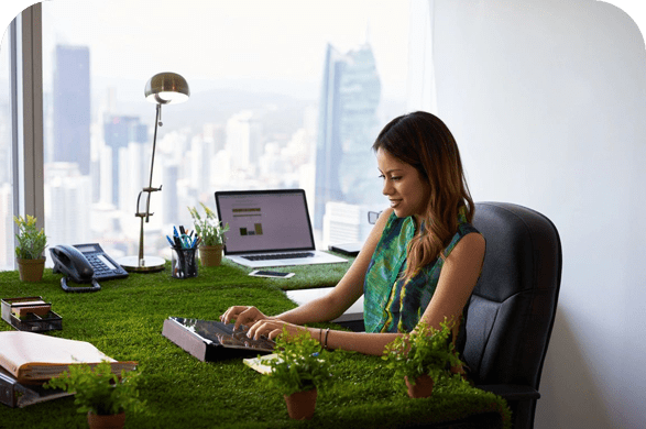 A woman sitting at her desk using a laptop.